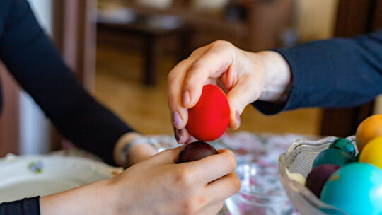 Hände klopfen Ostereier.