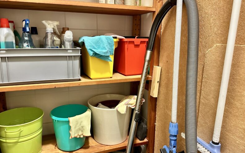 Putzschrank mit Besen, Staubsauger, Kübeln, Reinigungsmitteln und Mikrofasertüchern