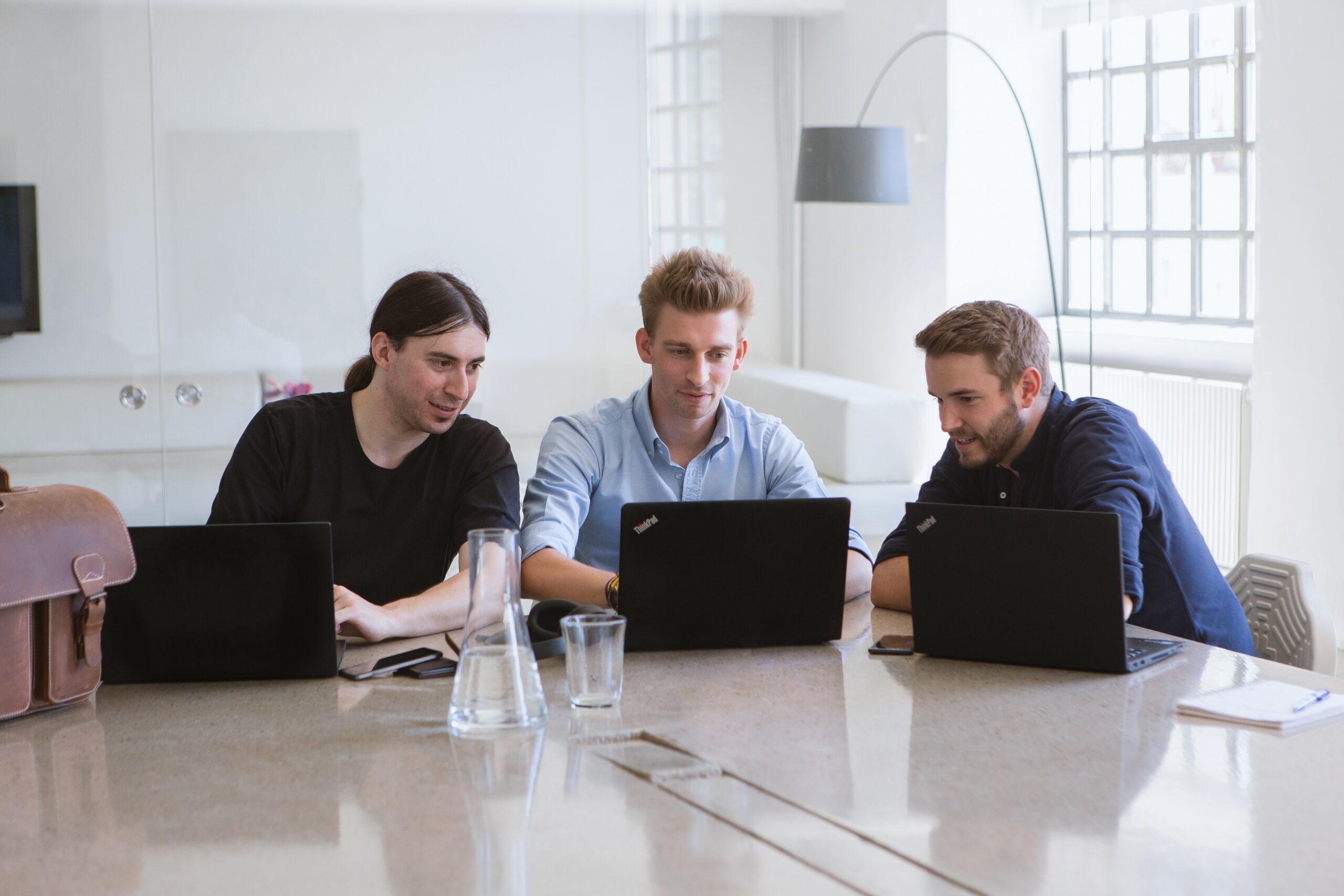 Das refurbed-Team im Gespräch, vor Laptops sitzend