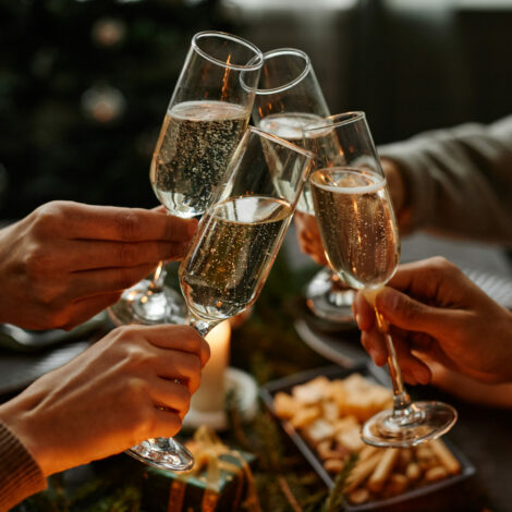 Freunde stoßen mit Sektgläsern und Sekt an.