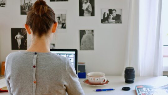 Stefanie vor dem Laptop an einem Tisch sitzend