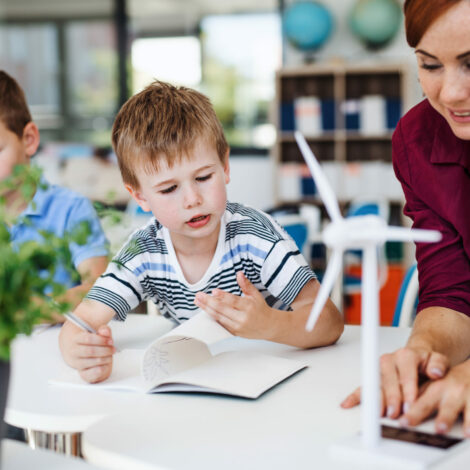 Gruppe von Schulkinder und Lehrerin reden über Windräder und Solarenergie