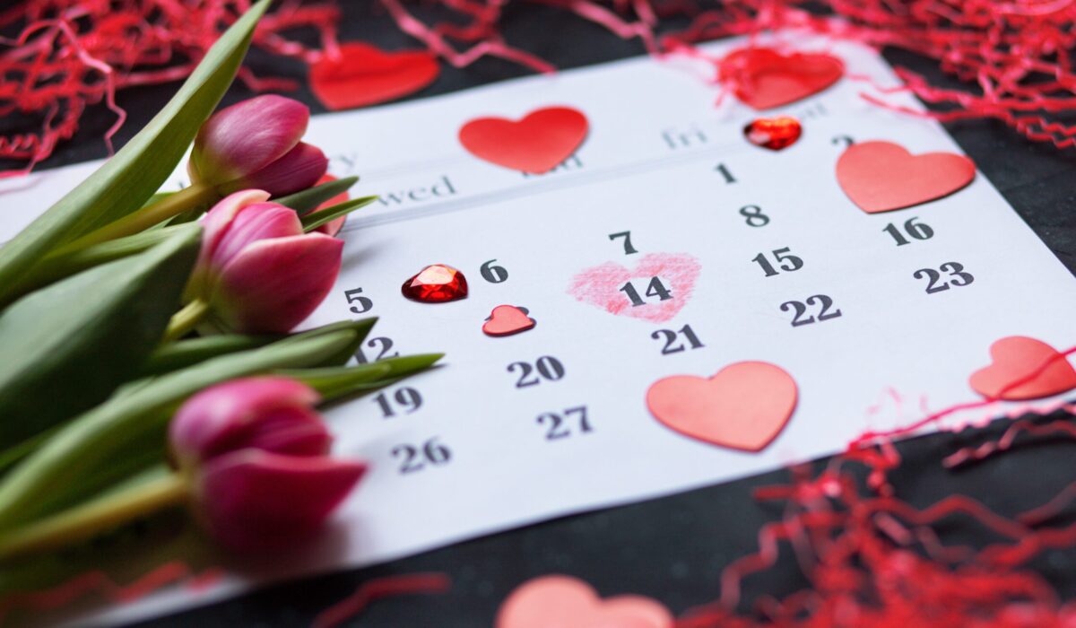 Kalenderblatt auf dem der 14 Februar mit einem Herz markiert ist und Tulpen drauf liegen