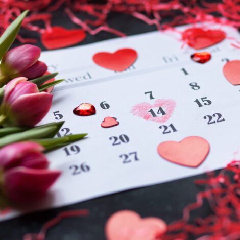 Kalenderblatt auf dem der 14 Februar mit einem Herz markiert ist und Tulpen drauf liegen