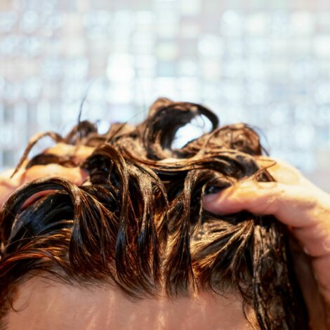 Frau wäscht sich die Haare unter der Dusche