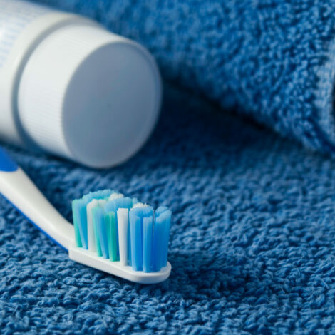Zahnbürste und Zahnpaste auf blauem Handtuch