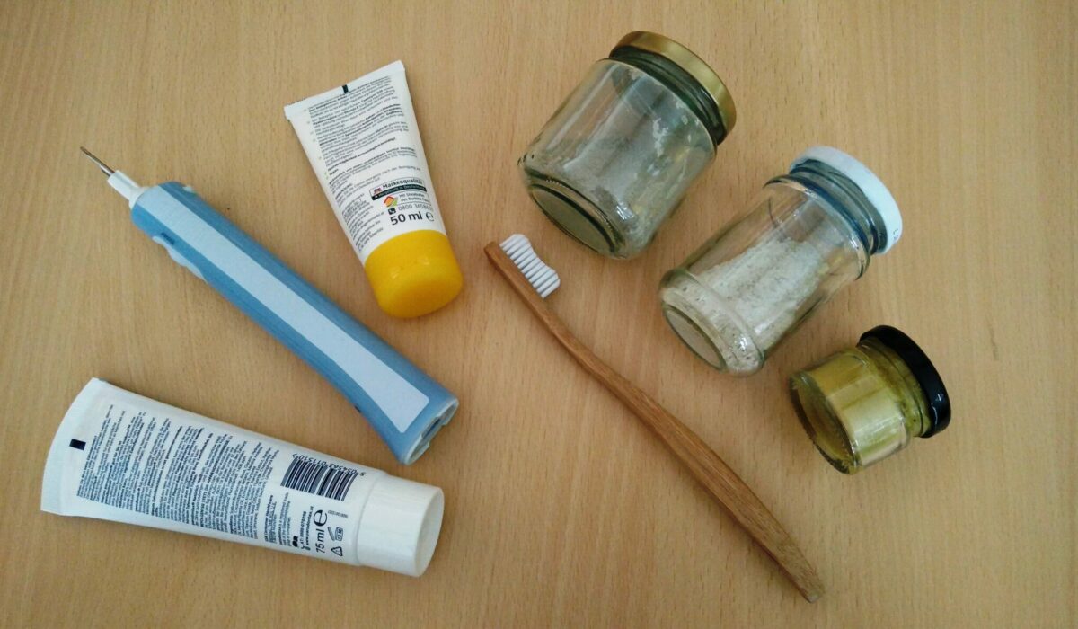 Zahnbürste, Zahnpasta und Creme einmal mit Plastik und einmal aus Holz und in Glasverpackung