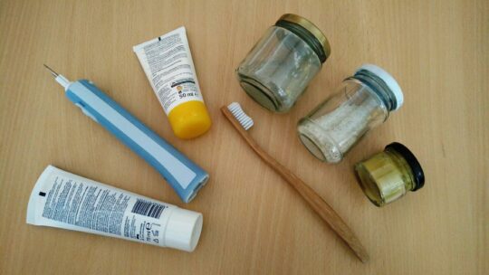 Zahnbürste, Zahnpasta und Creme einmal mit Plastik und einmal aus Holz und in Glasverpackung